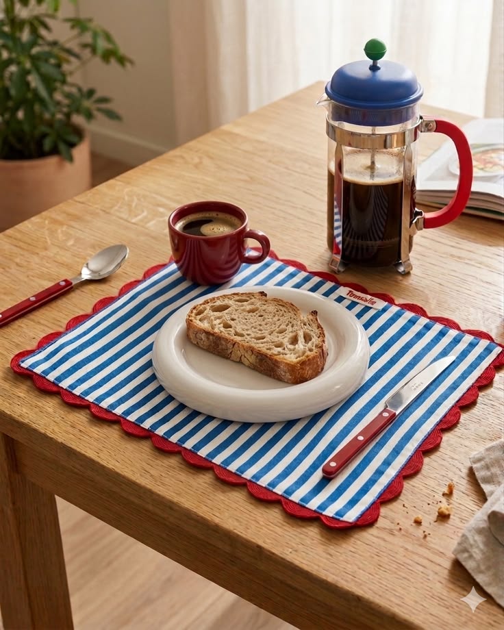 Breakfast place setting with striped table mat and ceramic pieces